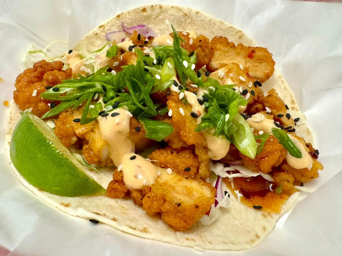 Fried shrimp taco with sriracha aioli and sesame